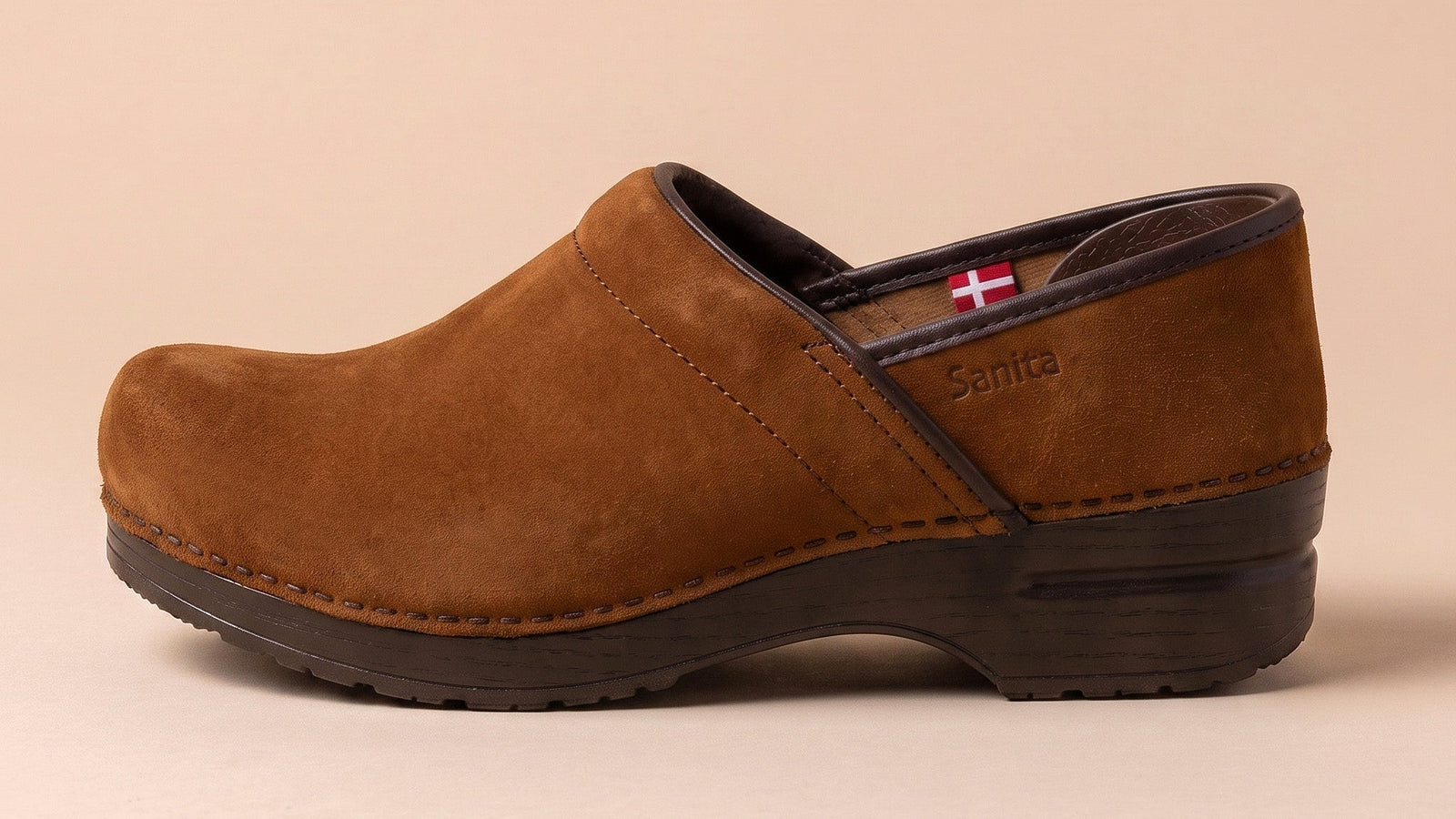 Cognac brown clog shoe on a soft beige pink background - Sanita Clogs