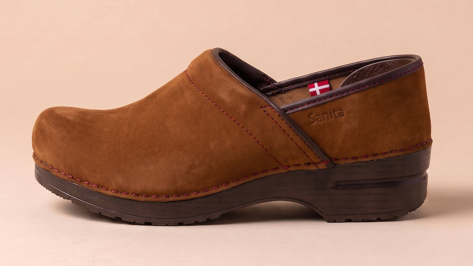 Cognac colored clog shoe with suede finish against tan background